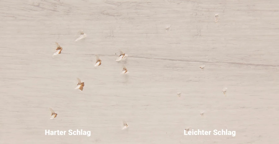 Heller Boden in Holzoptik mit Einschlagspuren, beschriftet mit harter und leichter Schlag